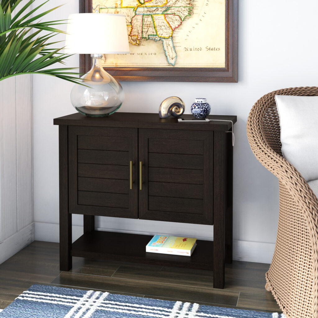 A brown console table holds a lamp and a few item decor as it sits in a short hallway.