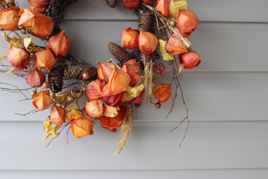 a fall vine wreath decorated with plant flowers and other natural elements to create a fall wreath for the front door 